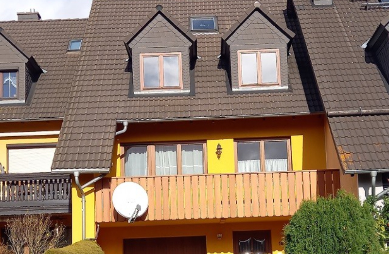 Dieses Bild zeigt ein gelbes Reihenmittelhaus mit Balkon in Dorfchemnitz.